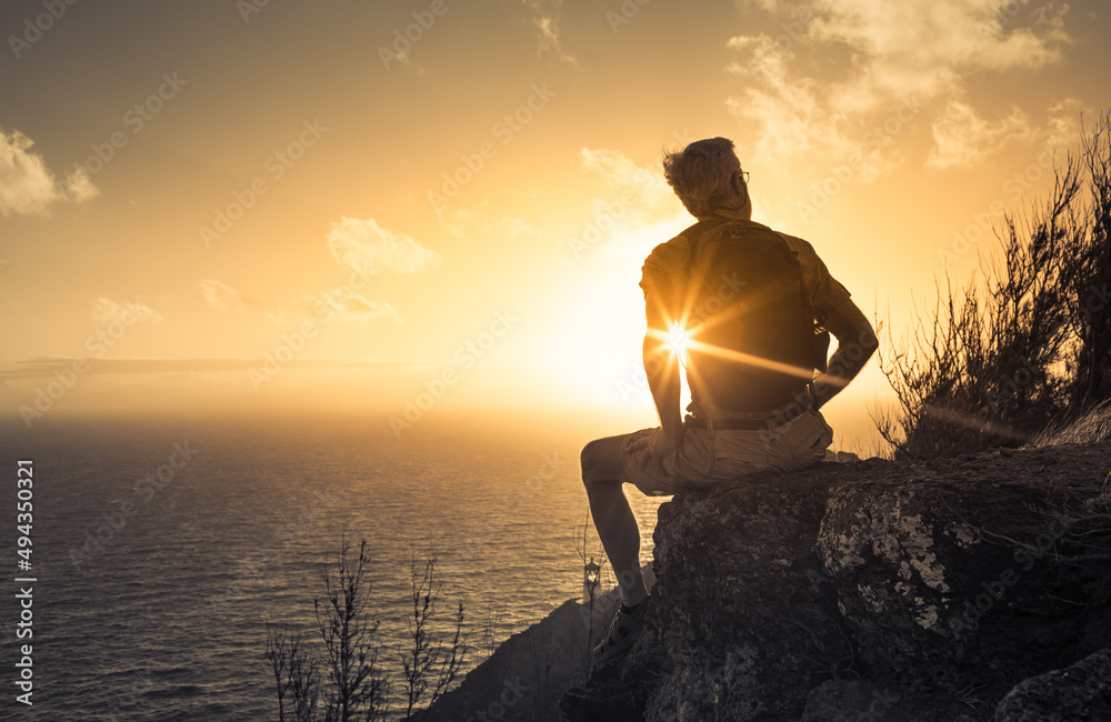 Its a beautiful life. Man on a mountain looking out to the beautiful sunrise 