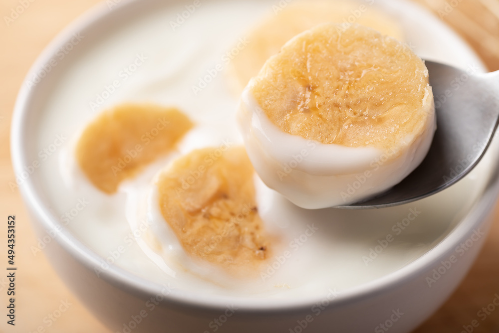 Yogurt with banana in bowl eating by spoon, Healthy food Yogurt with banana in bowl eating by spoon, Healthy food