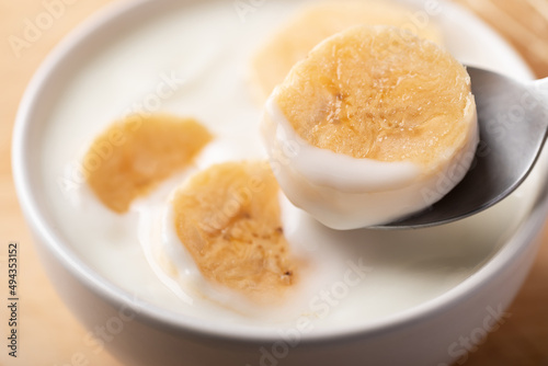 Yogurt with banana in bowl eating by spoon, Healthy food