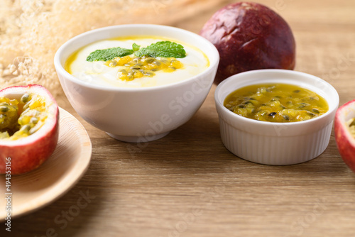 Yogurt with passion fruit juice in bowl on wooden background, Healthy eating