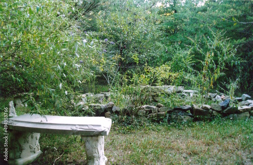 Abandoned well in the park wtih bench