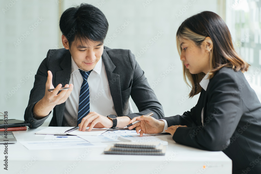 Businesspeople smiling coworking commenting and showing growth graphic and taking a business conversation in an office interior Businesspeople smiling coworking commenting and showing growth graphic and taking a business conversation in an office interior