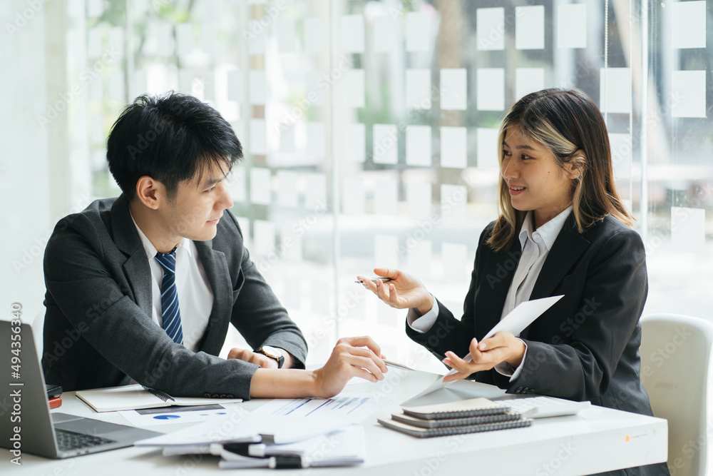 Businesspeople smiling coworking commenting and showing growth graphic and taking a business conversation in an office interior Businesspeople smiling coworking commenting and showing growth graphic and taking a business conversation in an office interior