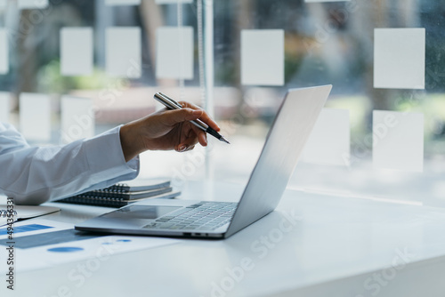 Female businesswoman readind financial report analyzing statistics pointing at pie chart working at her desk photo