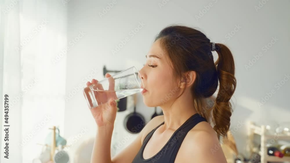 Asian beautiful woman in sportswear drink water after exercise at home Asian beautiful woman in sportswear drink water after exercise at home