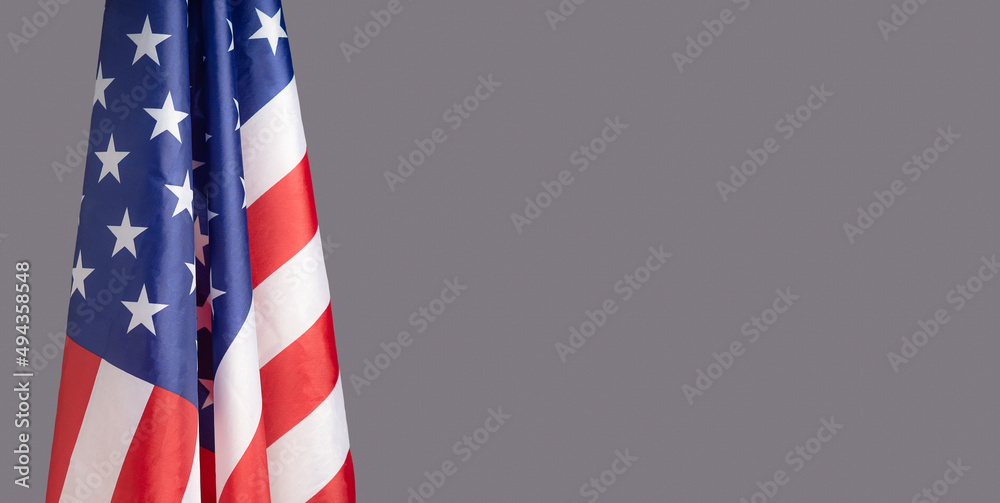 lose-up of the American flag is on the left side on a gray background lose-up of the American flag is on the left side on a gray background