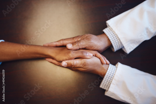 Im here to help you get through this challenge. Closeup shot of an unrecognizable doctor holding a patients hand in comfort.