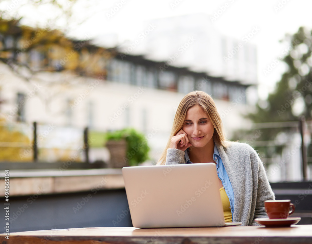 Fresh air and free wifi. Cropped shot of an attractive young woman using her laptop at an outdoor coffee shop.