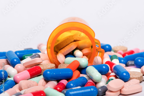 Medical pills and tablets spilling out of a drug bottle.