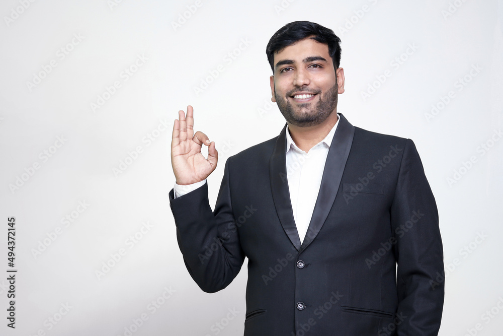 Portrait of a cheerful young man showing okay gesture isolated on the white isolated background. Portrait of a cheerful young man showing okay gesture isolated on the white isolated background.