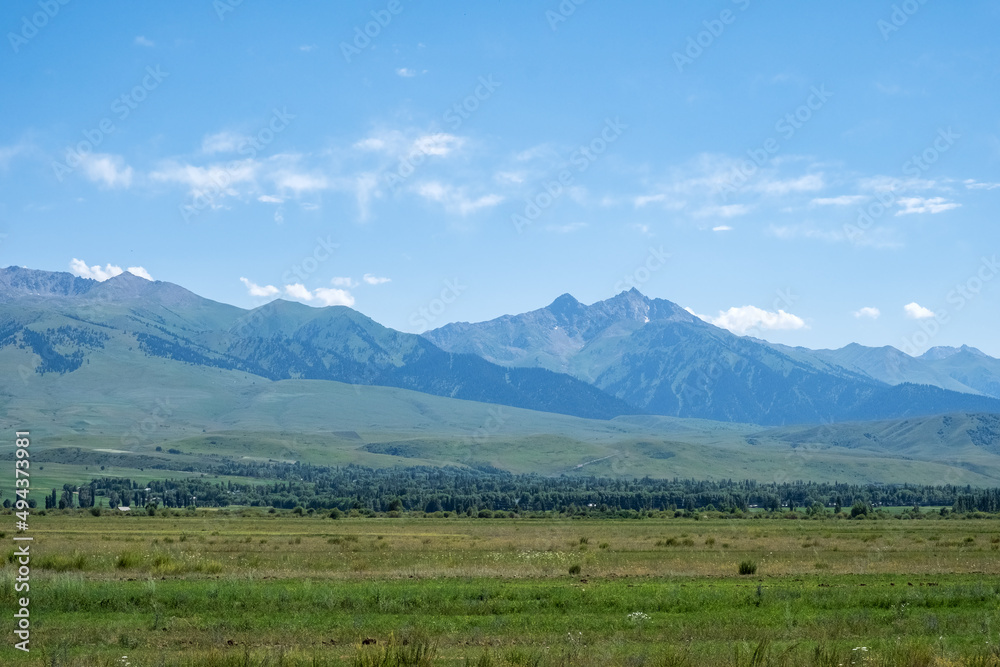 Beautiful green mountains with blue sky background. Santash mountain pass in Kyrgyzstan.
