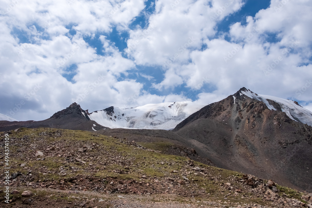 Mountain range with glacier on the top. Glacier on rocky mountains. Melting glaciers due to global warming climate change problem. Barskoon mountain pass.