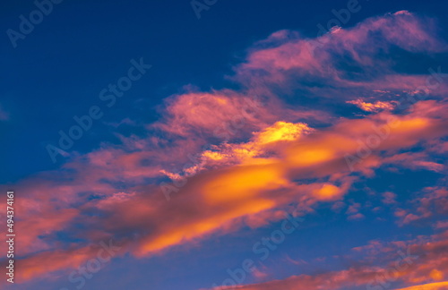 colorful dramatic sky with clouds, smoking cumulonimbus clouds reflect the golden light of the dawn sun. © Anatolii 