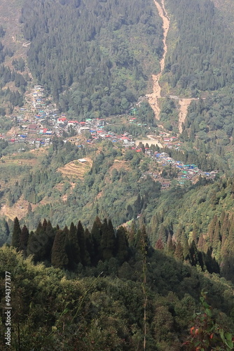 forest covered himalayan foothills and mountain village mane bhanjang from simana basti view point, at nepal india border, darjeeling, west bengal, india photo