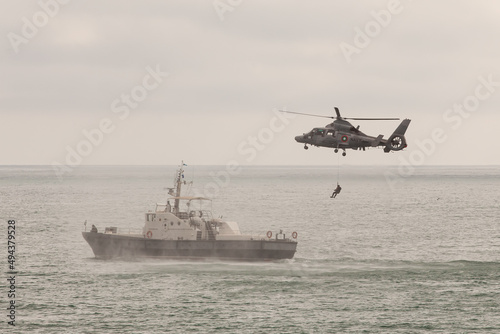 Special operations forces training. Military helicopter over ship. photo