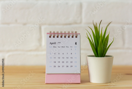 Desktop calendar for April 2022 for planning on the table.