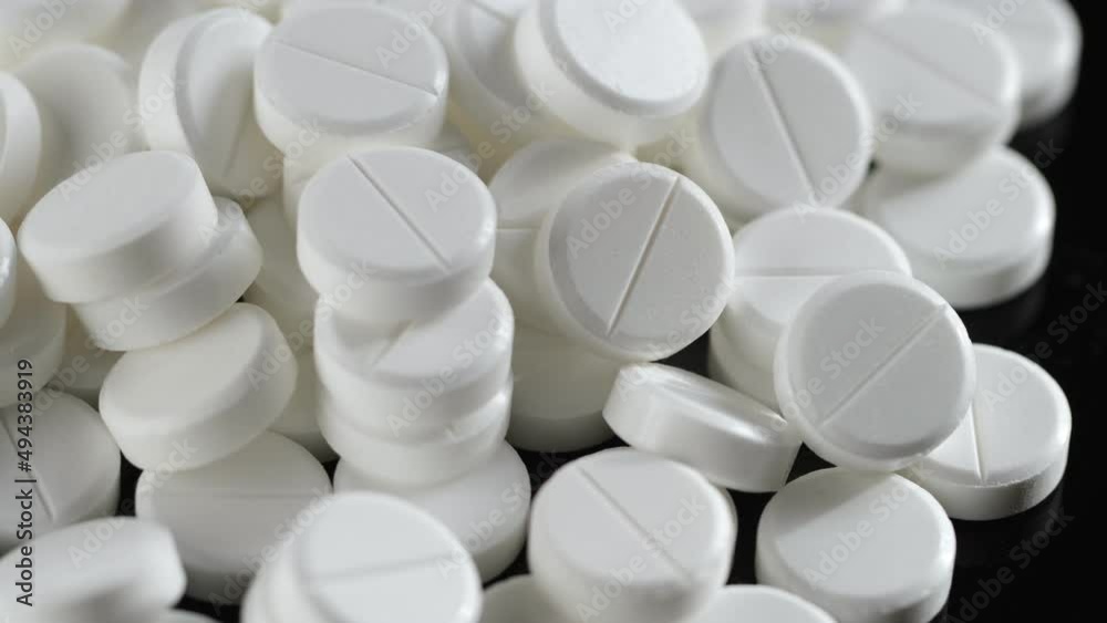 Many white round pills. Pharmaceutical production. Drugs on the production line. Moving background. close-up. view from above. white medical pills rotating closeup. Pills and drugs. Pharmaceutical Many white round pills. Pharmaceutical production. Drugs on the production line. Moving background. close-up. view from above. white medical pills rotating closeup. Pills and drugs. Pharmaceutical