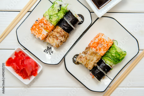 Several sushi on a white plate standing on a white background
