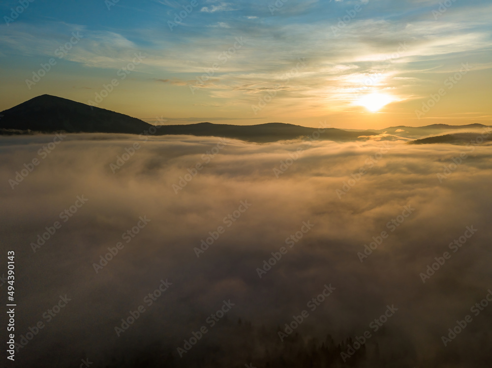 The rays of dawn over the fog in the Ukrainian Carpathians. Aerial drone view. The rays of dawn over the fog in the Ukrainian Carpathians. Aerial drone view.