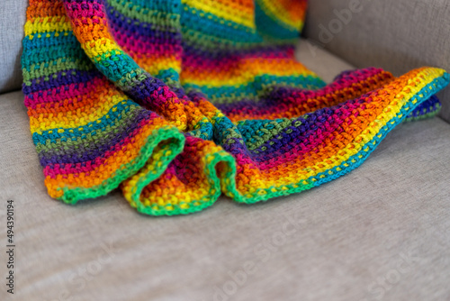 knitted colourful blanket on lounge 