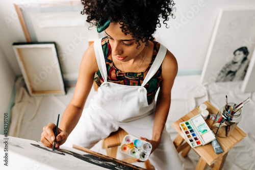 Fototapeta Naklejka Na Ścianę i Meble -  Female artist painting on a canvas in her art studio