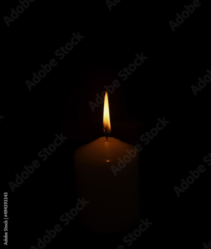 Burning candle on black