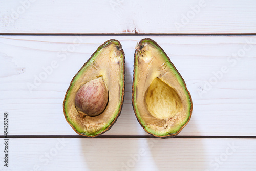 Slika na platnu A rotten avocado on a light wooden background