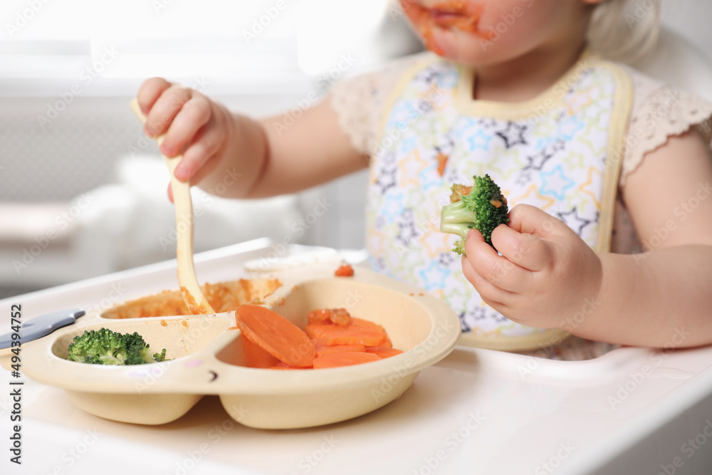 Little baby eating food in high chair, closeup Little baby eating food in high chair, closeup