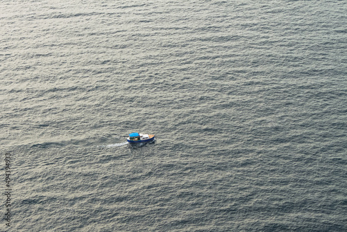 A small fishing motorboat in the middle of the sea. A fishing boat in the calm Black Sea. View from above.