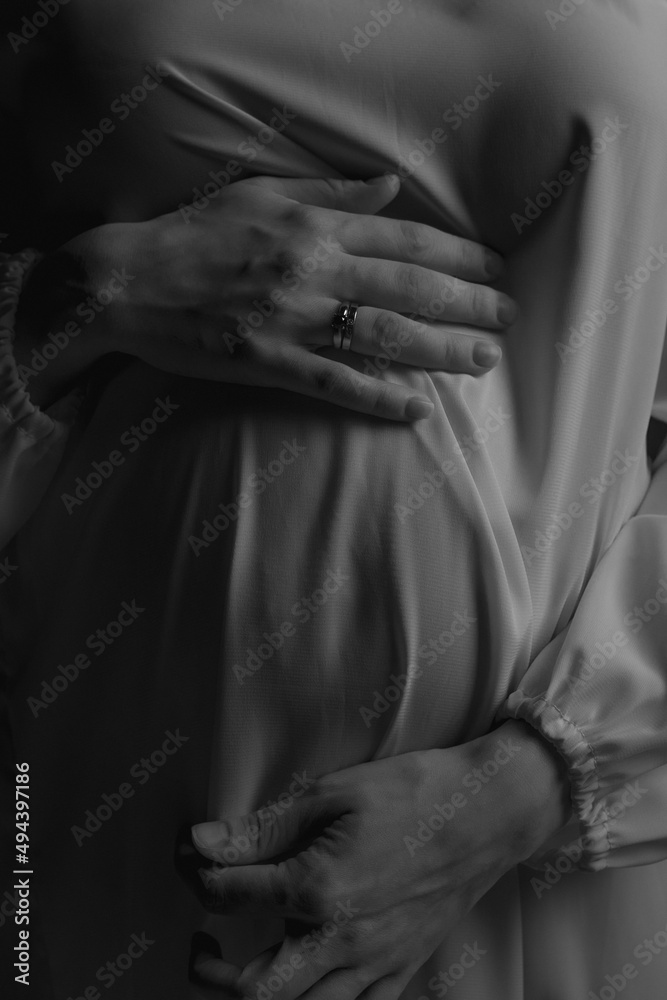 a pregnant woman holds her hands on her stomach