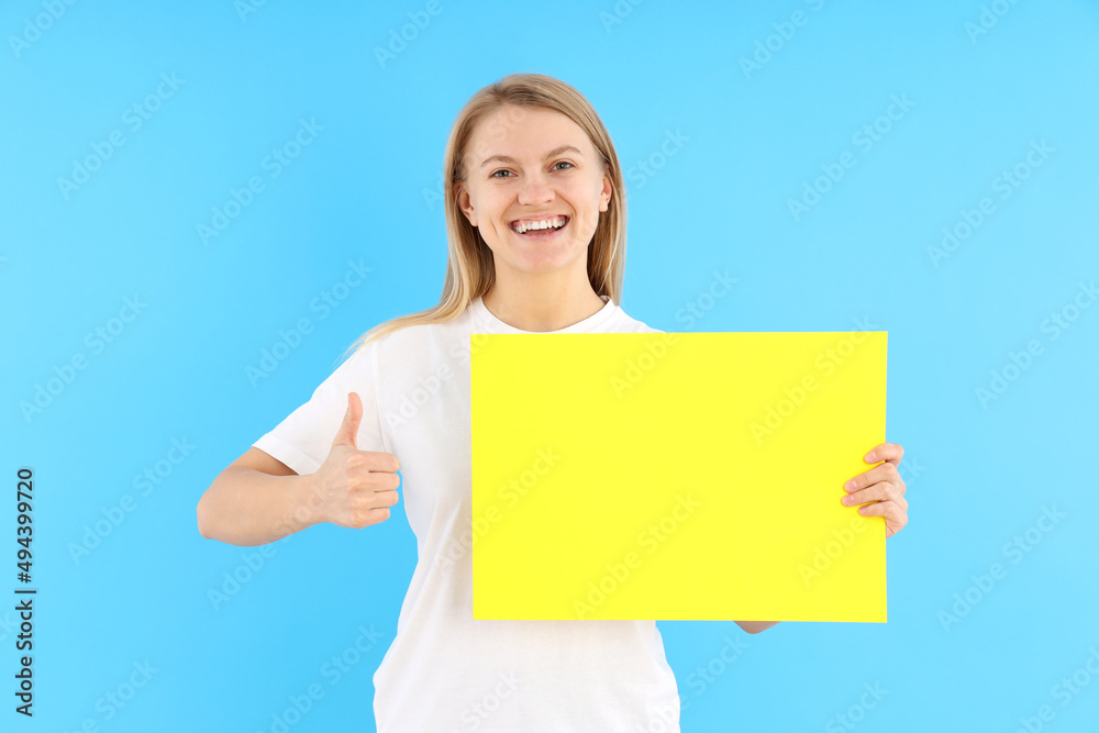 Woman holding blank banner on blue background Woman holding blank banner on blue background