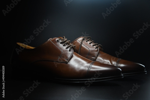 Photo of dark brown shoes on black background