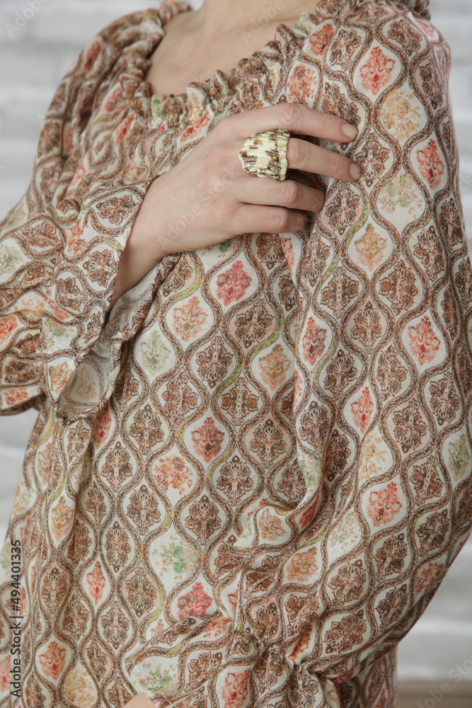 Close up of woman in textured linen blouse with brownish geometric print