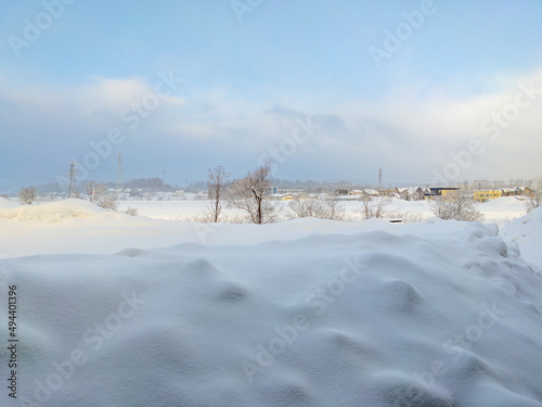 Viewing a snowfield with houses from behind a building (Kutchan, Hokkaido, Japan) © Mayumi.K.Photography