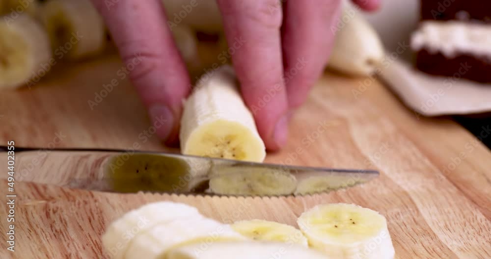 slicing a ripe yellow banana into pieces during cooking slicing a ripe yellow banana into pieces during cooking