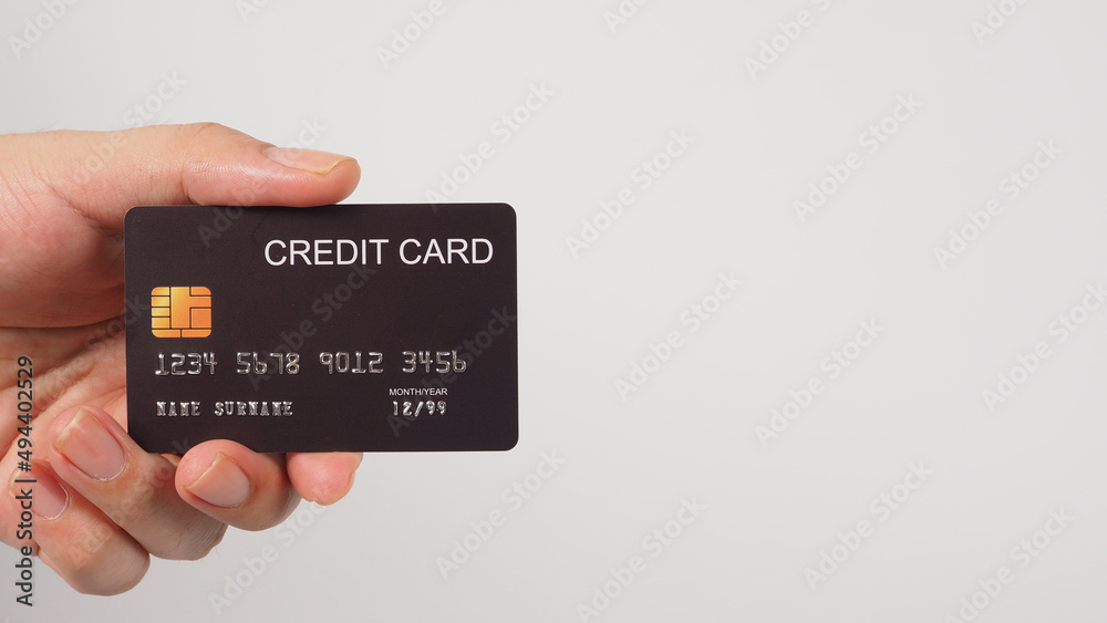Hand is holding black credit card isolated on white background Hand is holding black credit card isolated on white background