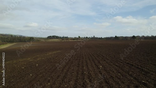Drone flying low over freshly ploughed fields in Scotland