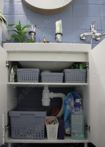 convenient beautiful storage of laundry and cleaning products in a small bathroom
