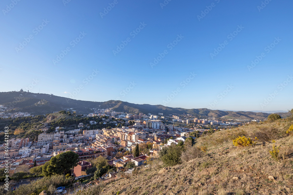 View of the city of Barcelona from the mountain on a sunny day. Urban landscape. Blue sky over the city.