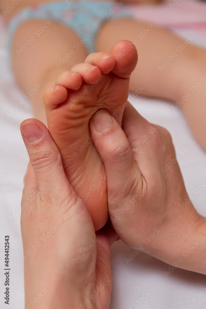 Doctor performing pediatric foot massage to prevent development of flat feet Doctor performing pediatric foot massage to prevent development of flat feet