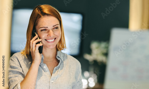Cheerful businesswoman speaking on a phone call in an office