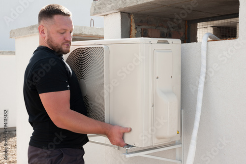 the worker installing and connecting a new air conditioner unit