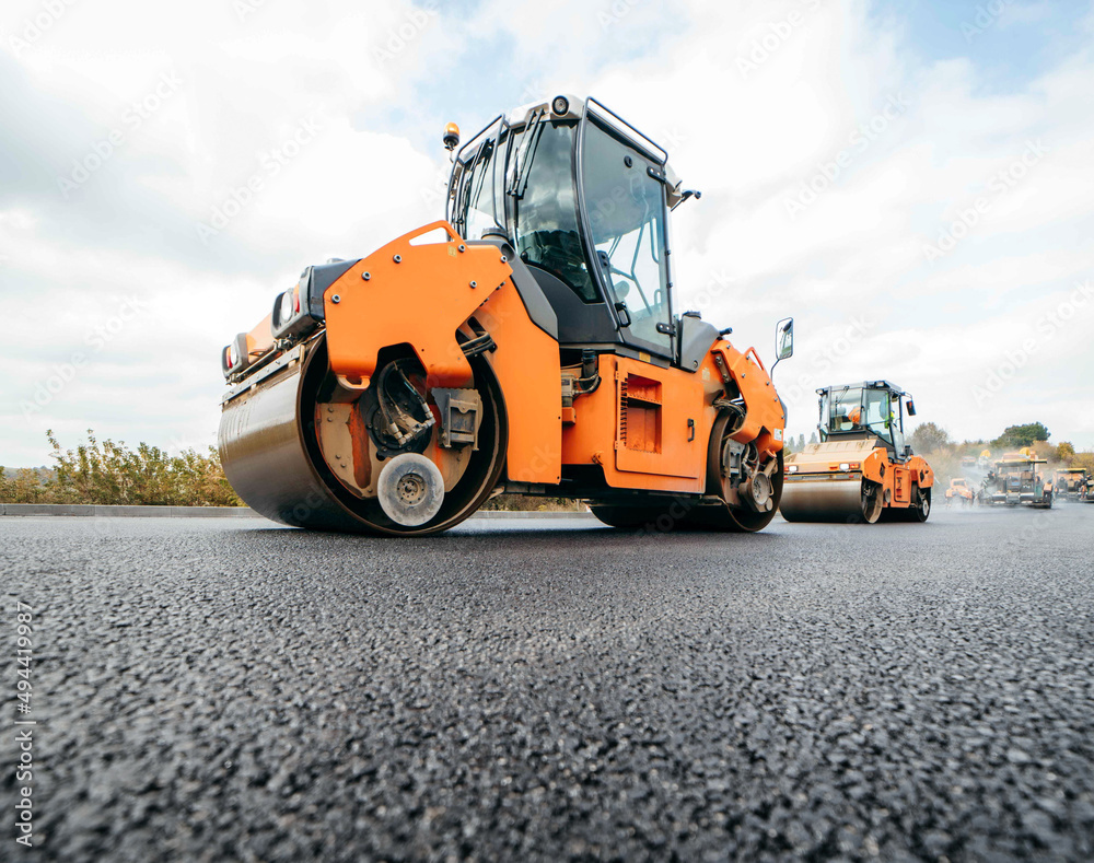 Vibratory asphalt rollers compactor compacting new asphalt pavement. Road service build a new highway Vibratory asphalt rollers compactor compacting new asphalt pavement. Road service build a new highway