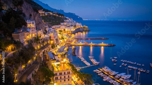 Amalfi town timelapse at night of marina in Italy's southwest coast street light cars light streaks boats coming and going town below cliffs photo