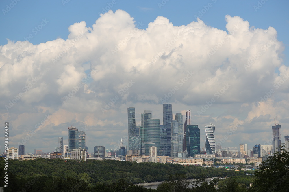 Beautiful view of the business center of Moscow on a sunny summer day with large white clouds in the sky.
