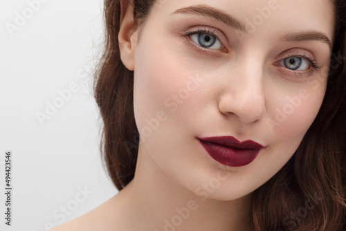 Young girl with burgundy lipstick on her lips, long hair, close-up.