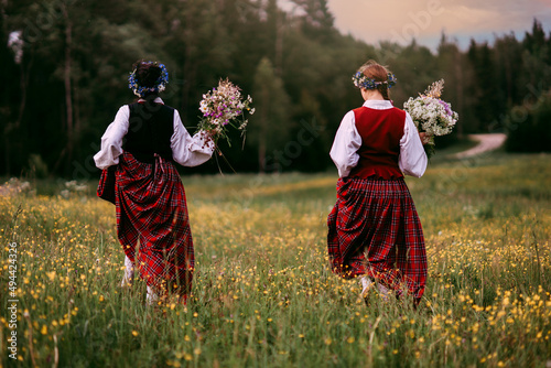 Latvian folk girls in traditional costume. Latvia summer. Symbolism of Latvia for Ligo holiday. Midsummer in Latvia. Traditional Latvian midsummer food. Celebration of Ligo in june decorating home wit