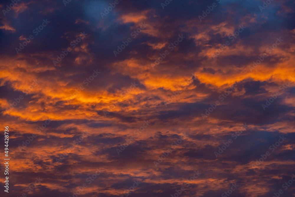 Colorful clouds in the rays of the setting sun