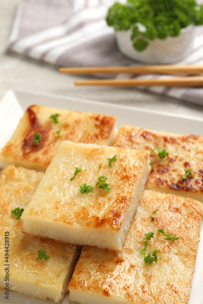Delicious turnip cake with parsley served on light table, closeup Delicious turnip cake with parsley served on light table, closeup
