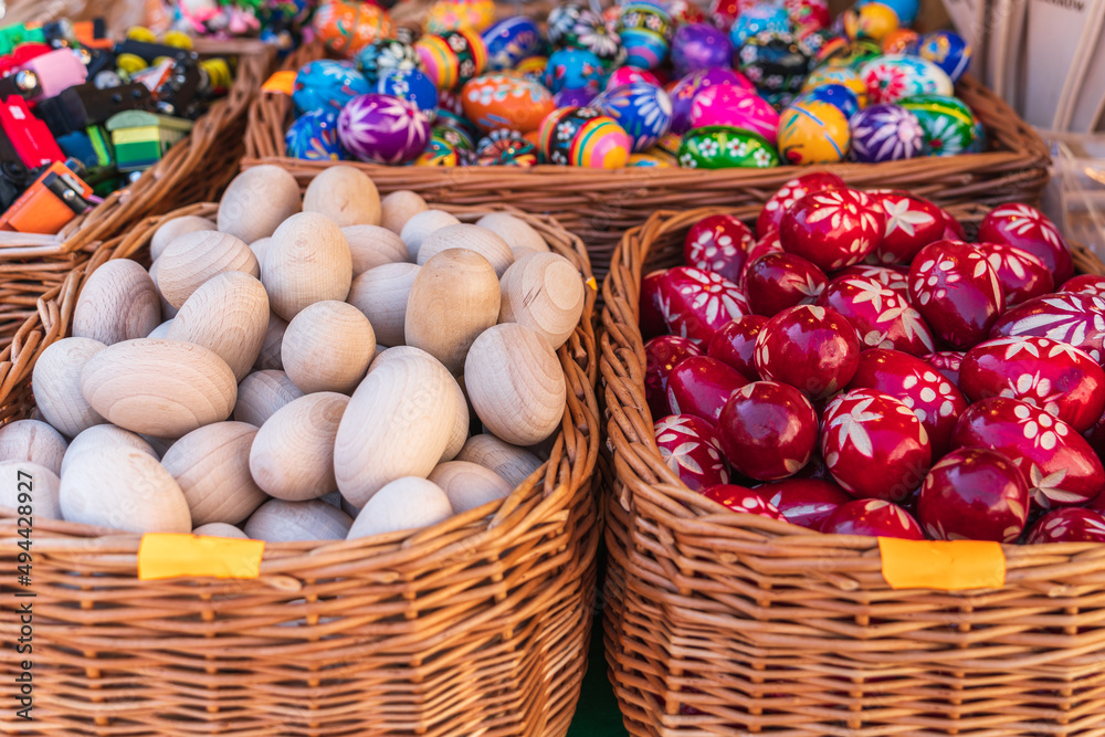 Baskets of handmade Easter eggs on the counter of the Easter market in Krakow. Spring holiday background. Traditional symbols of Easter. selective focus